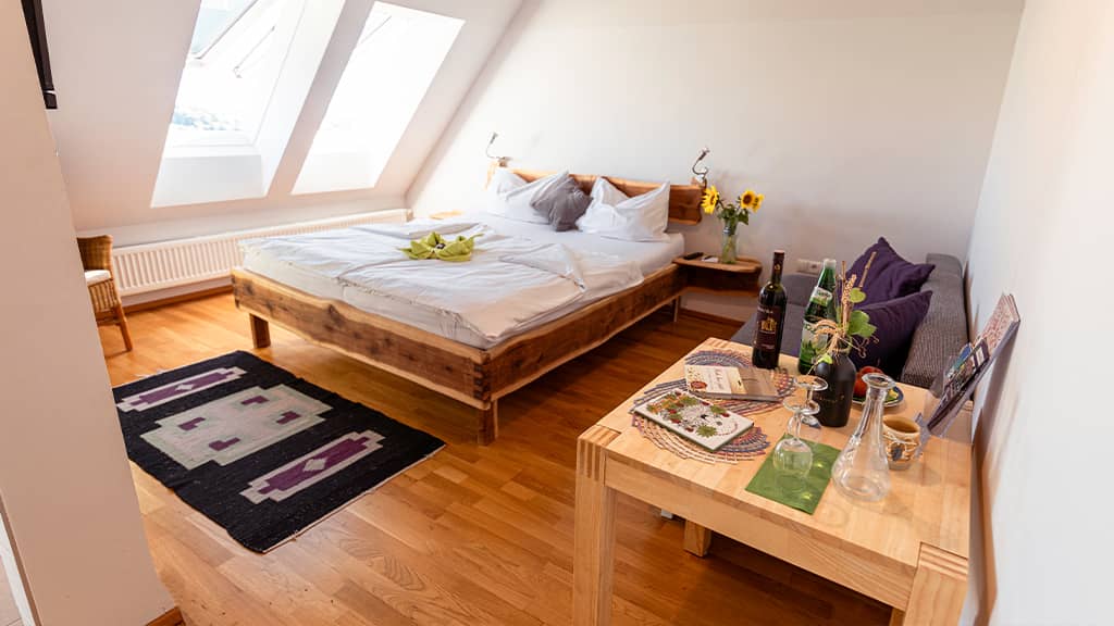 Das Bild zeigt ein Schlafzimmer mit einem urigen Doppelbett aus Holz.